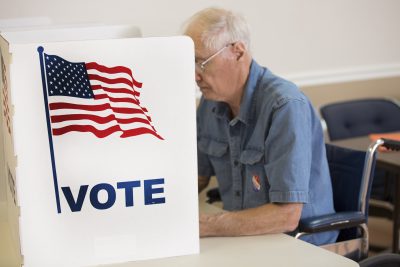 Senior man votes on election day in a wheel chair